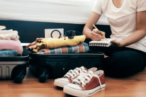 Woman preparing luggage for a trip using a list