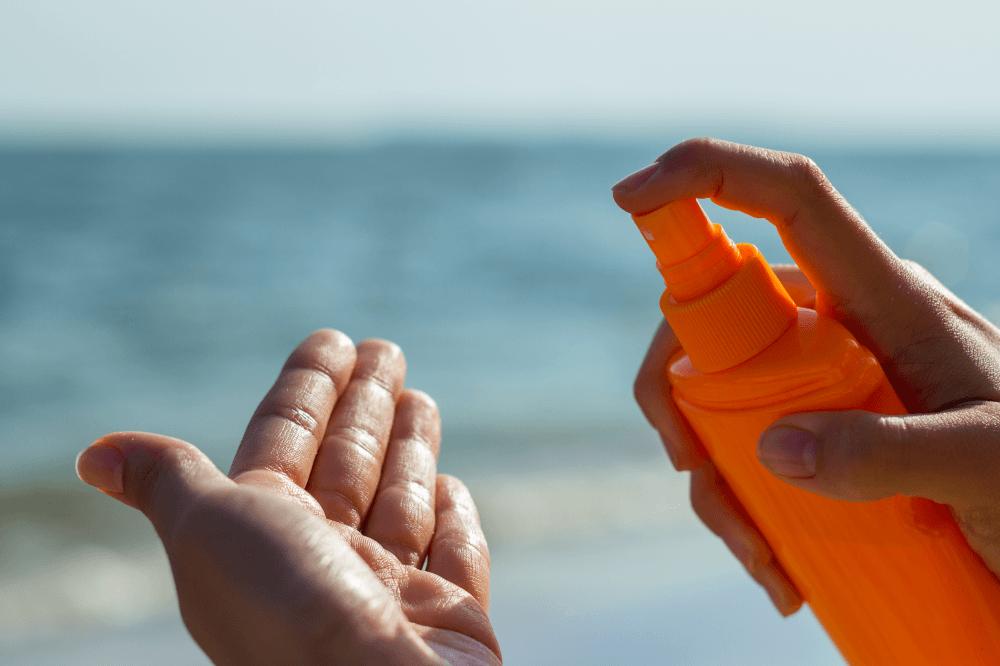 Woman using sun screen protection by the seashore