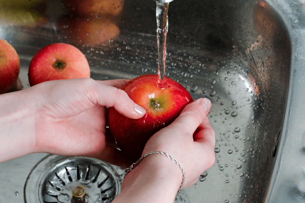 Woman washing apples in the sink