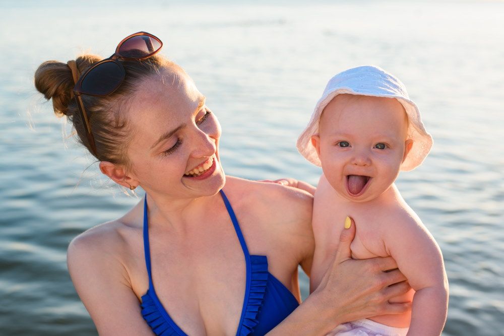 Happy Mother With Baby At The Beach