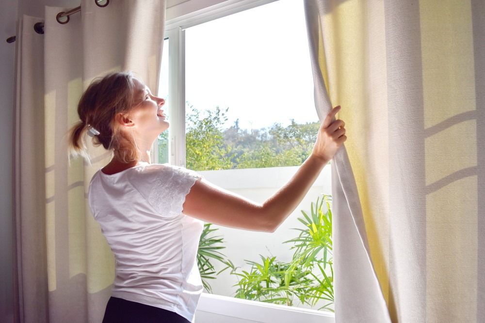 Young woman opening windows